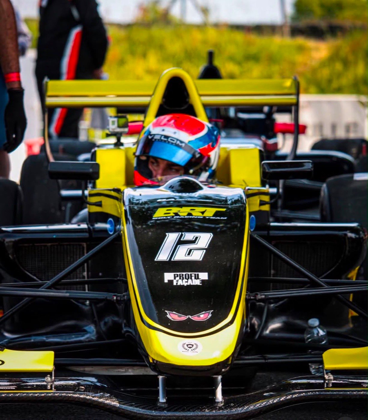 Pilote auto monoplace Formule 4 BRT Racing Team #12, casque et combinaison course — coaching mental sport auto