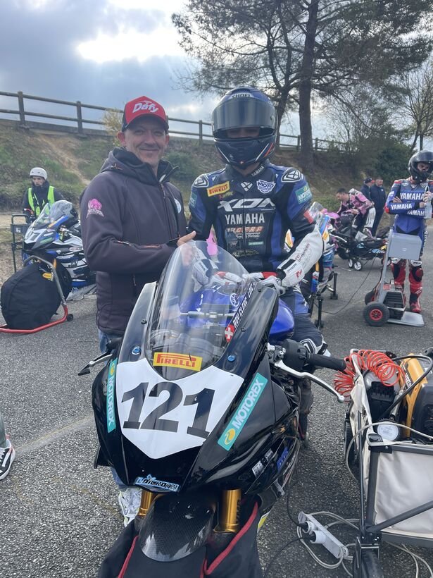Philippe Ciminera coaching un jeune pilote moto en combinaison Yamaha #121 sur le paddock — accompagnement junior 8-18 ans
