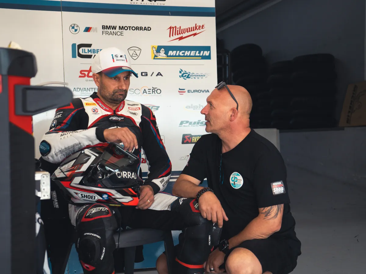 Philippe Ciminera en échange avec un pilote assis dans le box, avant de rouler